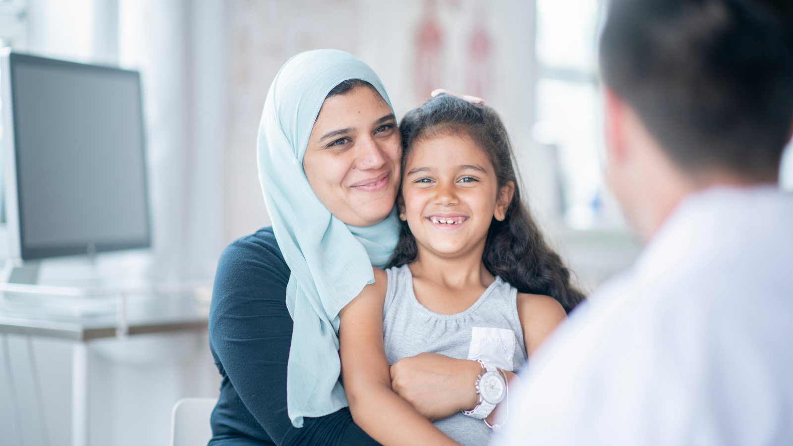 A mother and daughter being welcomed at a neighborhood clinic